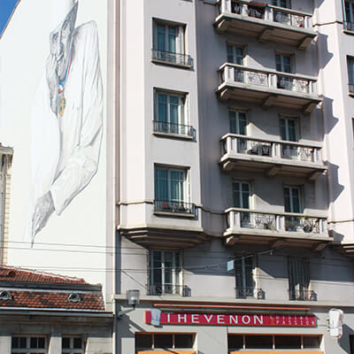 Photo de la boutique particulier avec la fresque Paul Bocuse sur le côté de l'immeuble